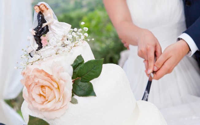Partir o bolo com as mãos dos noivos sobrepostas significa que a vida dos dois será compartilhada