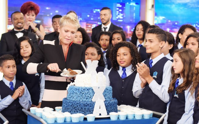 Xuxa corta seu bolo de aniversário ao lado do coral e convidados
